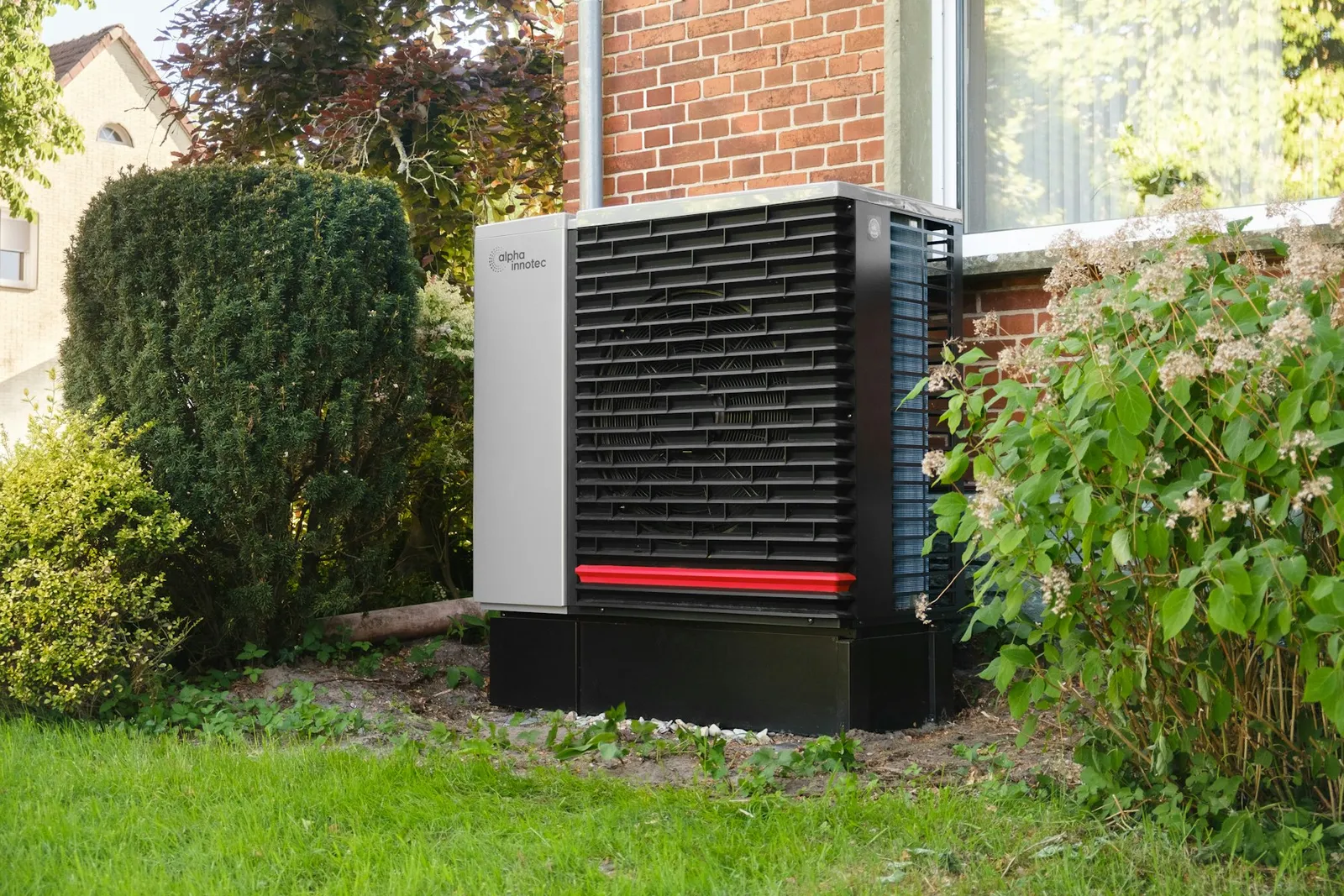 Pompe à chaleur air-eau installée contre une maison en briques